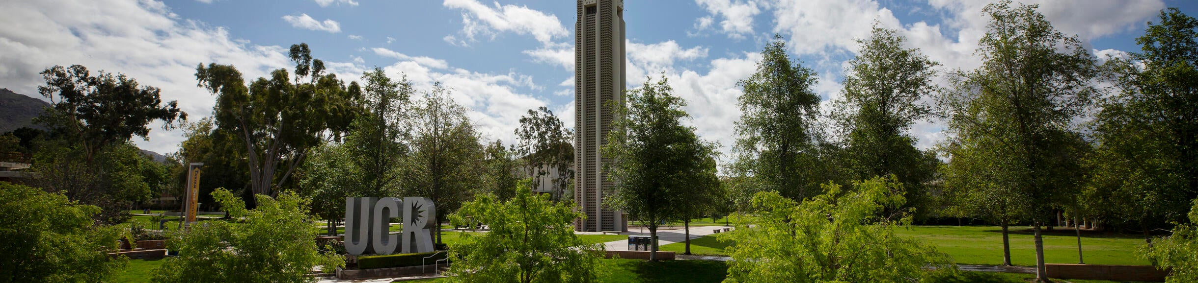 The bell tower and sign under blue skies on Thursday, March 19, 2020 at UC Riverside.  (UCR/Stan Lim)