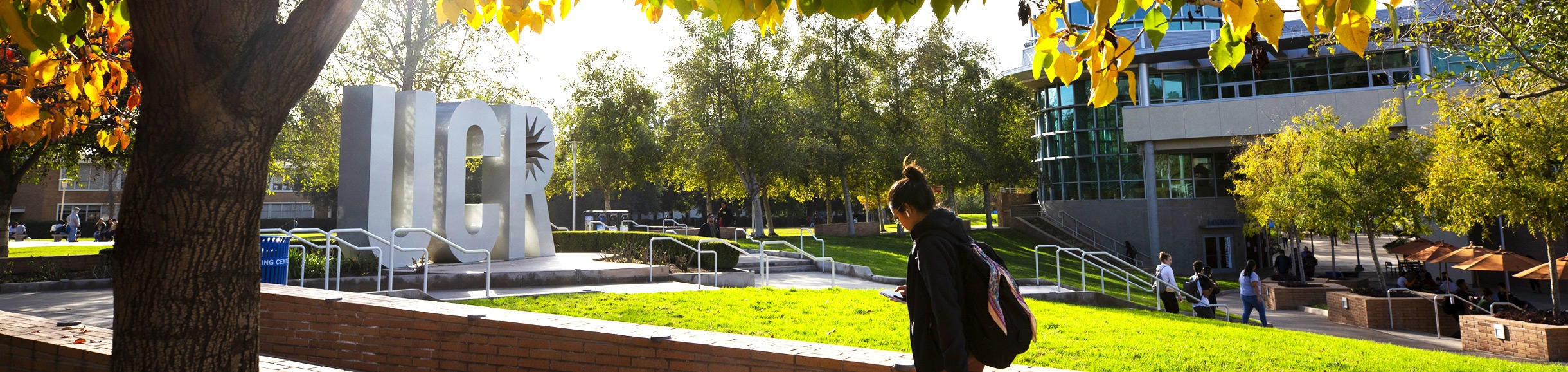 Student walking by the UCR sculpture at the HUB Plaza on the UCR campus